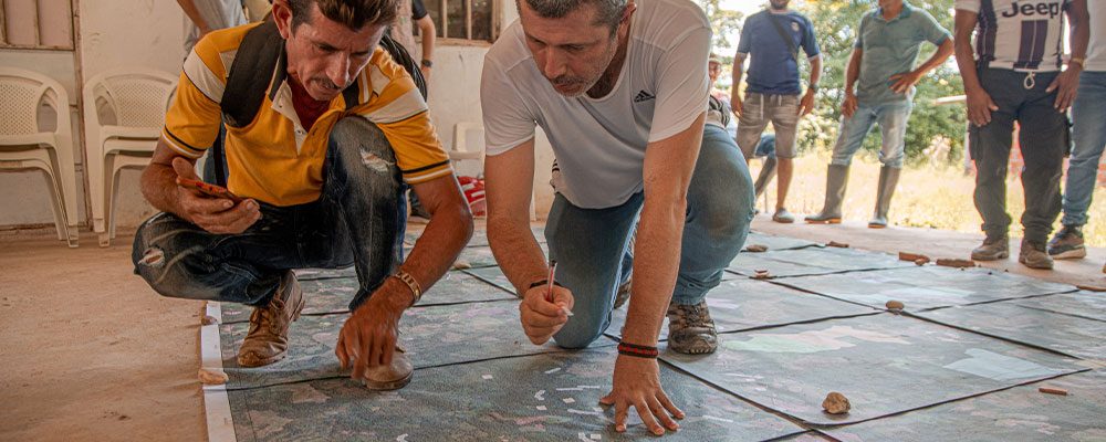 Dos señores estudiando un material geográfico.